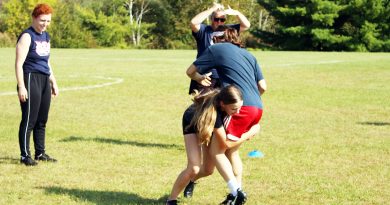 A girl tackles another girl during a rugby practice.