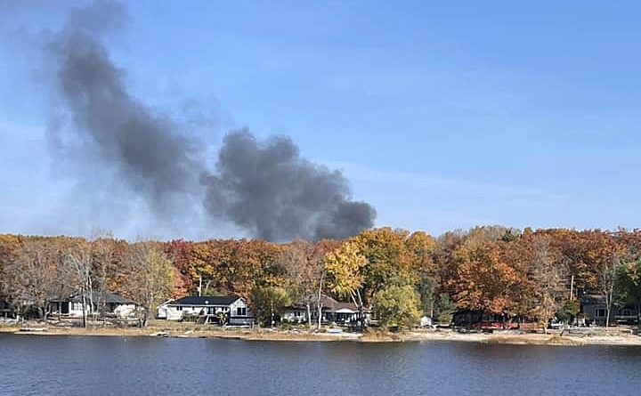 A photo o smoke rising over the forest.