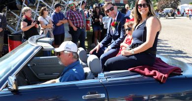 A family sits on the back of a car.