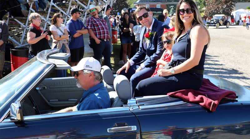 A family sits on the back of a car.