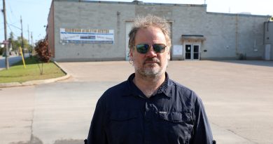 A man poses in an empty parking lot.