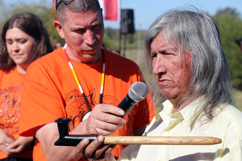 A man holds a pipe.