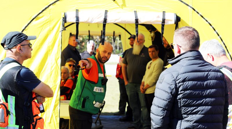 A man speaks in a large tent.