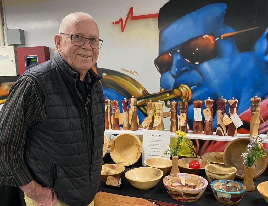 A man poses beside his art.