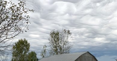 A photo of clouds over a barn.