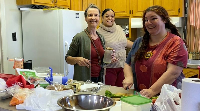 Volunteers pose in a kitchen.