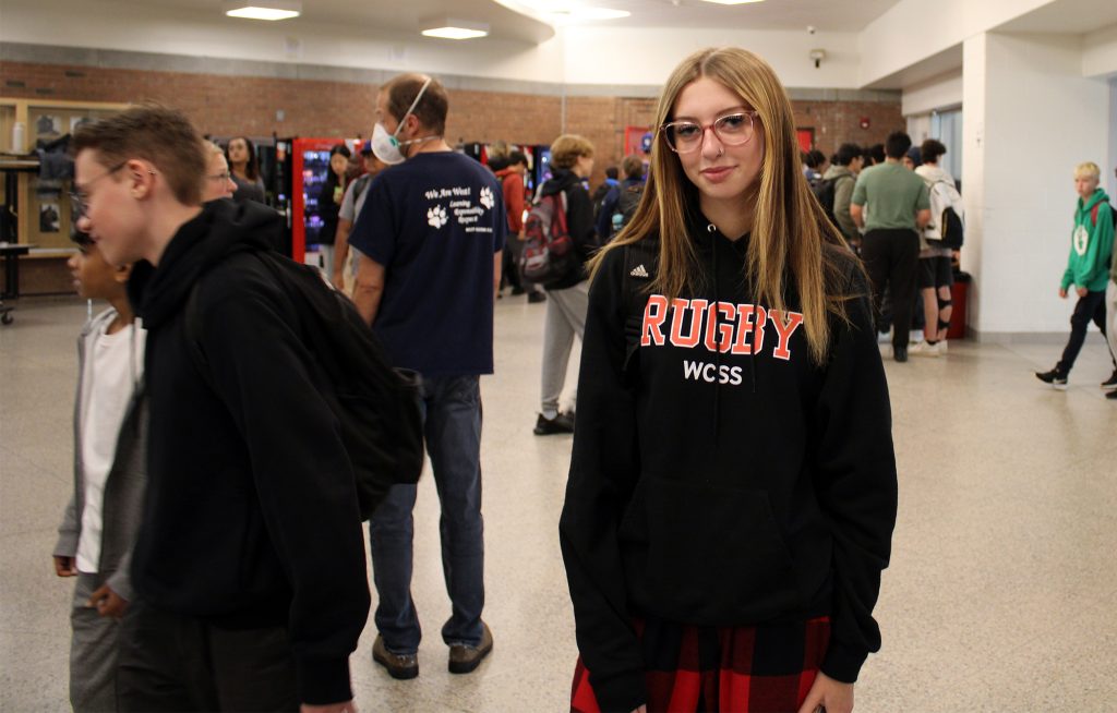 A person poses in a high school.