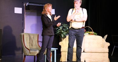 Two people talk on a stage.