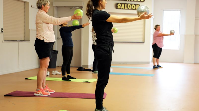 People excercise with a ball.