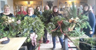 People pose with wreaths.