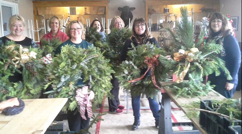 People pose with wreaths.