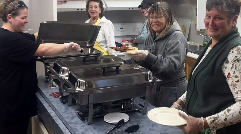 Volunteers cook breakfast.