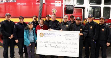 A group of firefighters and food bank volunteers pose for a photo.