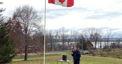 A man speaks at a flag.