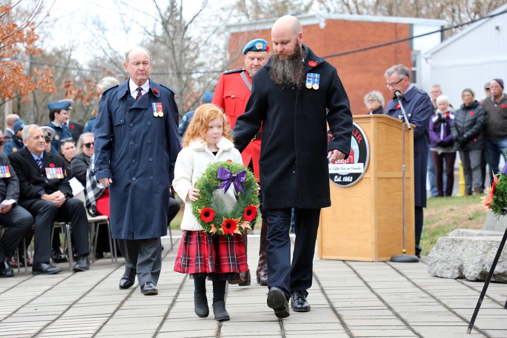 A family of four lay a wreath.