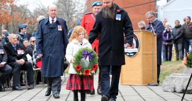 A family of four lay a wreath.