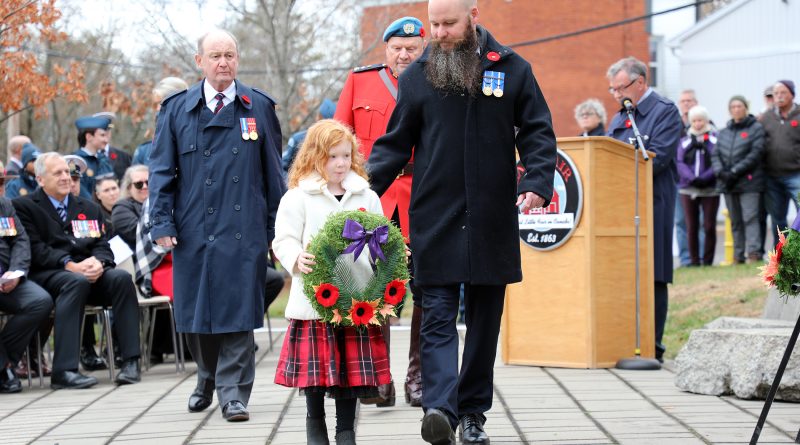 A family of four lay a wreath.