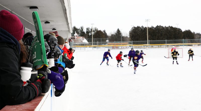 People play hockey outdoors.