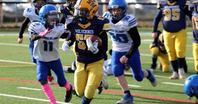 A football player runs with the ball.