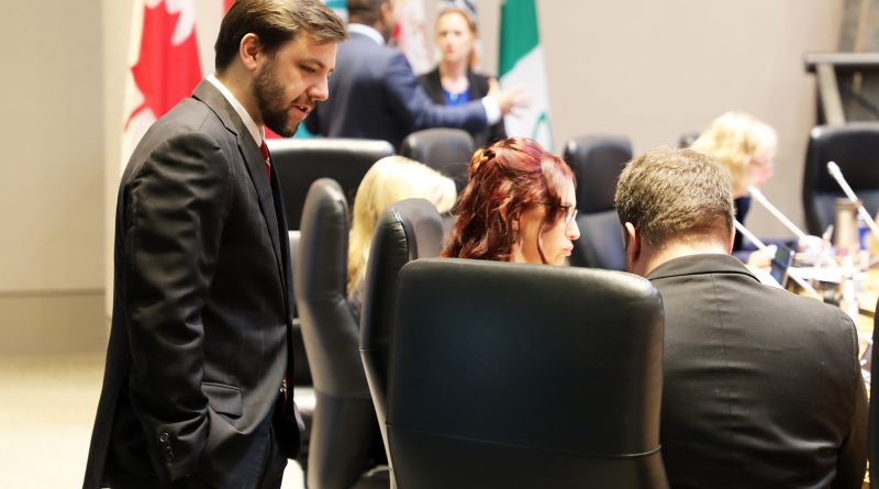 A councillor speaks to colleagues at the council table.