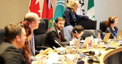 A photo of a councillor at the council table.