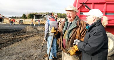 Two people talk on a farm.