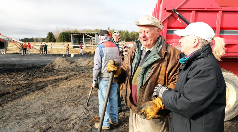 Two people talk on a farm.