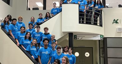 People pose for a photo on a set of stairs.