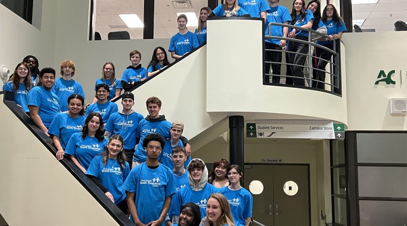 People pose for a photo on a set of stairs.