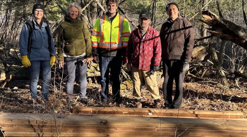 Five people pose for a photo.