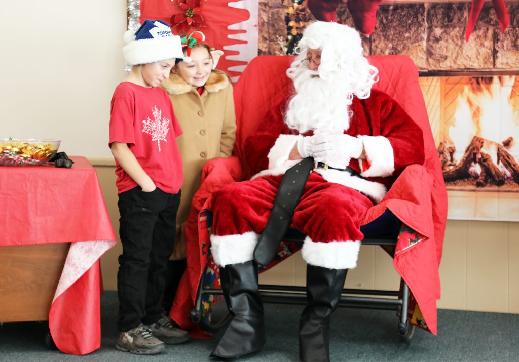 Two kids talk to Santa.