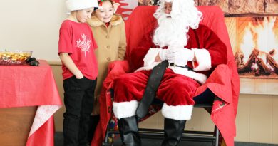 Two kids talk to Santa.