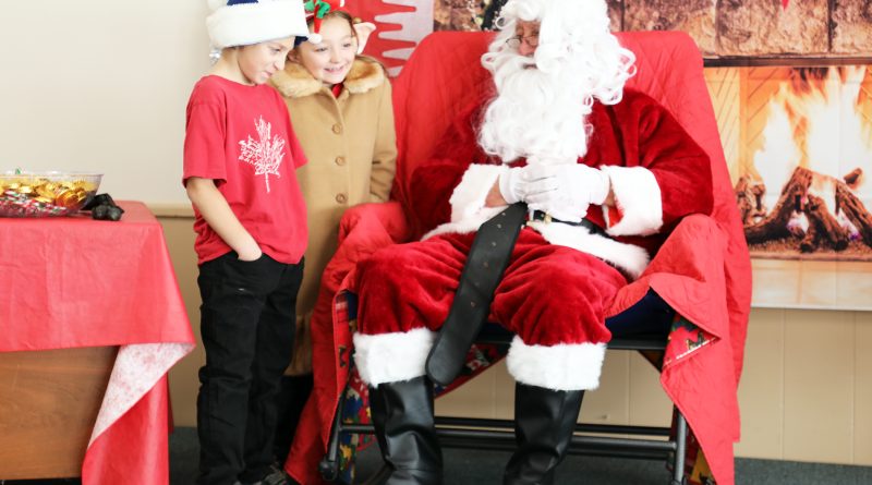 Two kids talk to Santa.