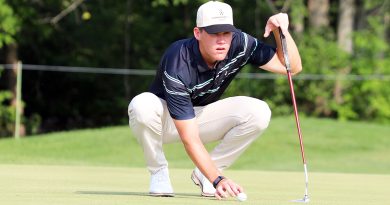 A golfer lines up a put.