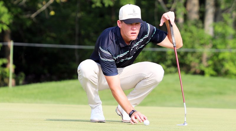 A golfer lines up a put.