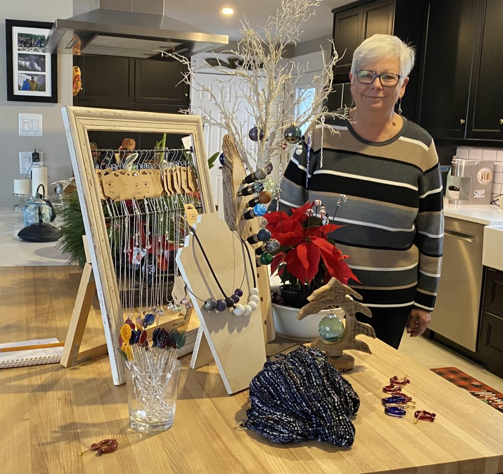 A woman pose with her glass jewelry.