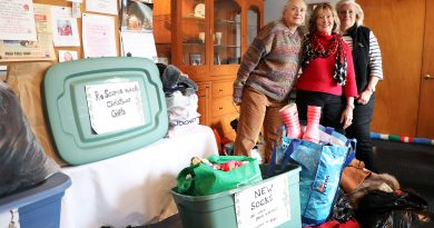 Three people pose with a huge donation.