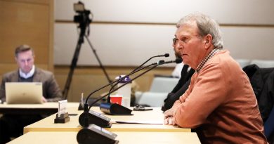 A man speaks at a microphone.