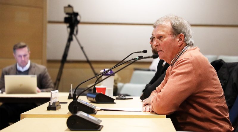 A man speaks at a microphone.