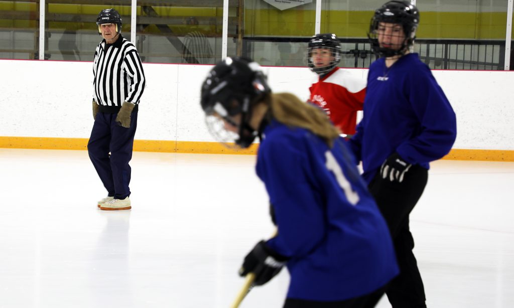 A man referees broomball.