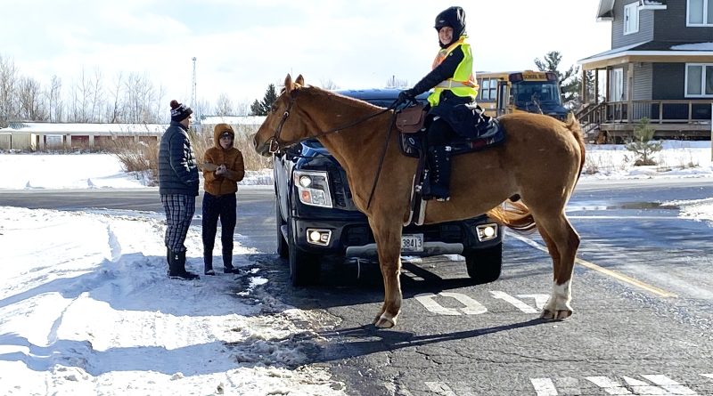 A woman on a horse talks to Dunrobin residents.