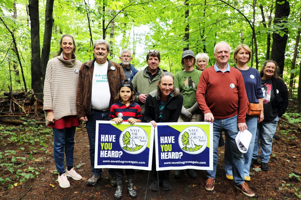 A group poses in a forest.