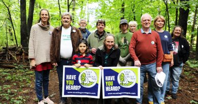 A group poses in a forest.