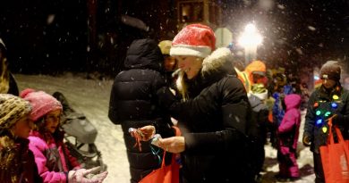 A woman hands out candy during a parade.