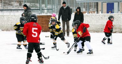 Kids play hockey outdoors.