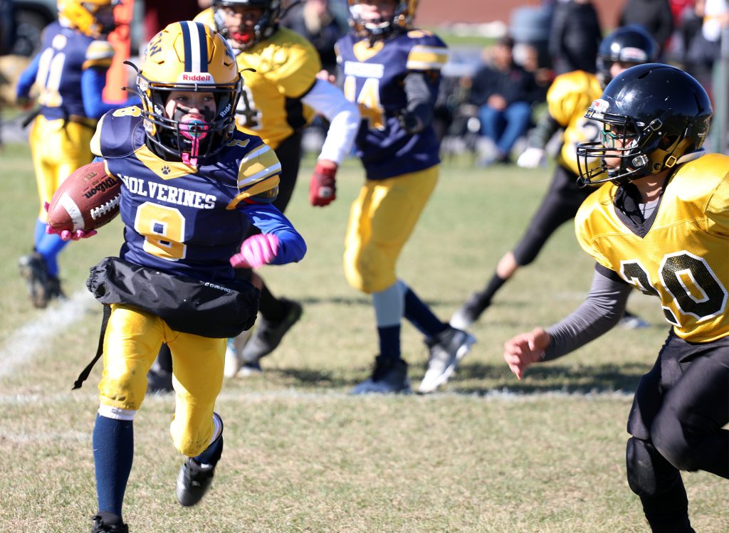 A football player runs with the ball.