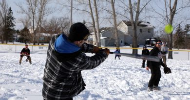 A player takes a swing during a snow pitch tournament.