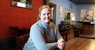 A woman poses in a pub.