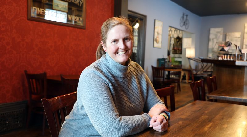 A woman poses in a pub.