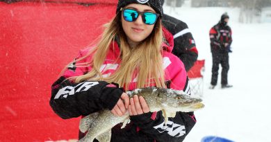 A young woman holds a big fish.